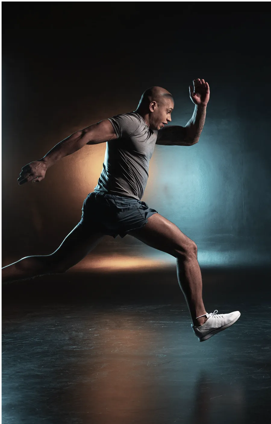 Male athlete sprinting indoors with motion blur.